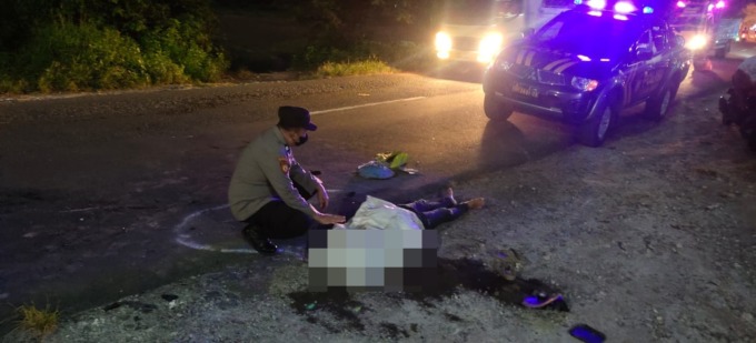 TERGELETAK: Anggota polisi melakukan evakuasi korban usai terlibat laka di Jalan Raya Kertosono, Kecamatan Sidayu, Senin (13/6).  (Ist./Radar Gresik)