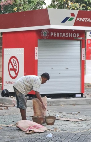 JUALAN BENSIN : Sejumlah pekerja terlihat tengah menyelesaikan pekerjaan perataan bisnis bensin eceran dilahan parkir BPPKAD. (Ist./Radar Gresik)