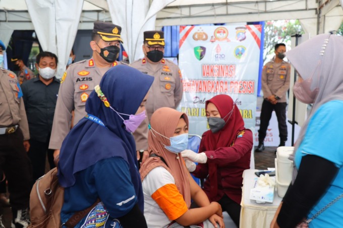 VAKSINASI: Kapolres Gresik AKBP Mochamad Nur Azis saat memantai langsung vaksinasi untuk warga dan pekerja pabrik di Kecamatan Driyorejo.  (Ist./Radar Gresik)