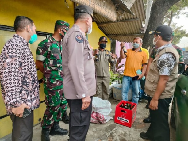 RAZIA: Anggota Polsek Duduksampeyan bersama petugas gabungan saat melakukan razia miras di sejumlah warkop sepanjang Jalan Duduksampeyan yang berdiri dekat rel kereta api. (ist/radar gresik)