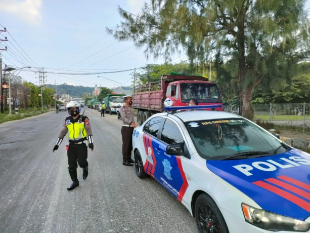 DITILANG: Anggota Satlantas Polres Gresik saat melakukan penilangam terhadap truk yang melanggar rambu larangan dilarang parkir di Jalan Raya Tridarma, Kecamatan Kebomas. (Yudhi/Radar Gresik)