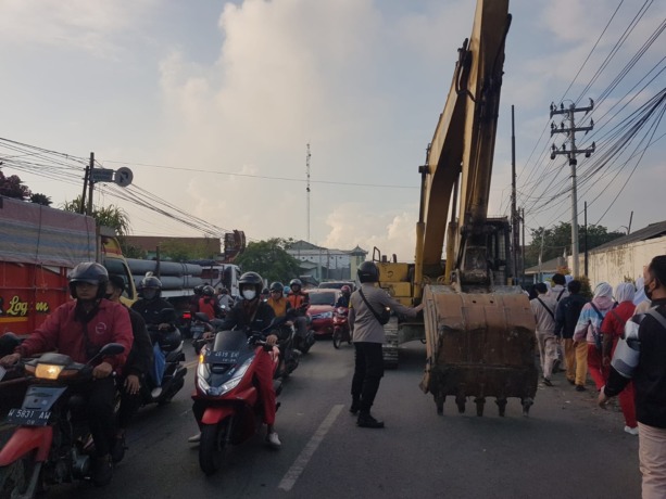 PERBAIKAN: Anggota Polsek Manyar mengatur lalu lintas saat pengerjaan proyek pelebaran Jembatan Tenger di Jalan Sukomulyo, Kecamatan Manyar, Rabu (13/7).  (Ist./Radar Gresik)