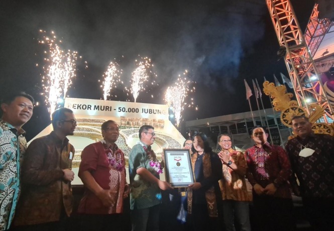 REKOR BARU: Direktur Utama PT Petrokimia Gresik, Dwi Satrio Anurrogo menerima piagam dari Museum Rekor Dunia Indonesia (MURI) sebagai perusahaan yang mempelopori pembuatan jajanan jenang jubung terbanyak di dunia. (Firman/Radar Gresik)