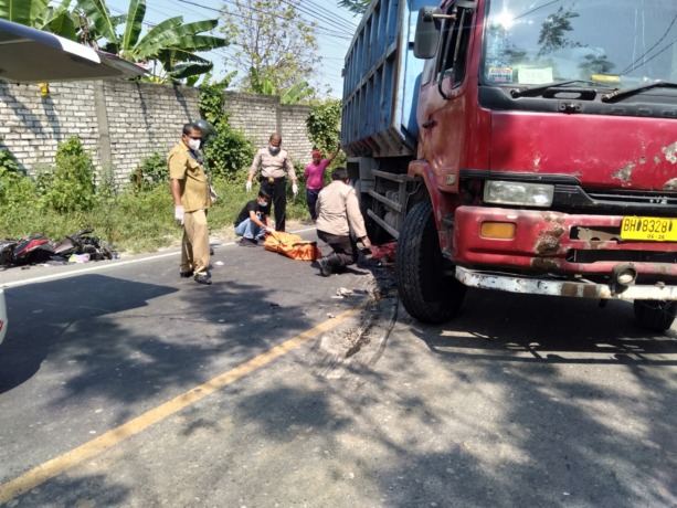 EVAKUASI: Anggota Polisi dan petugas kesehatan dibantu warga saat melakukan evakuasi korban laka terlindas truk di Jalan Raya Bungah pertigaan Dusun Gunungsari, Kecamatan Bungah. (Istimewa/Radar Gresik )