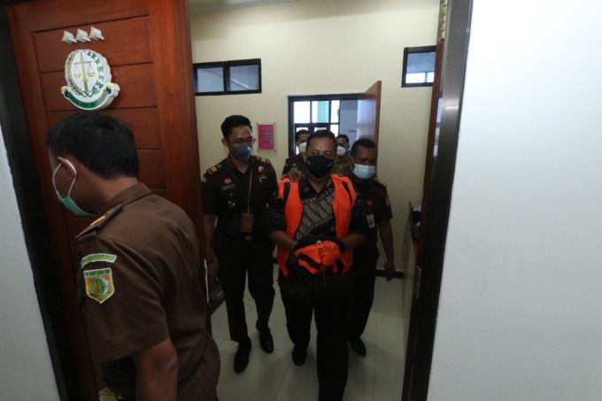 DITAHAN: Kepala Desa Roomo Rusdianto digelandang menuju mobil tahanan kejari Gresik untuk ditahan di Rutan Kelas II B Gresik. (Dok/Radar Gresik)