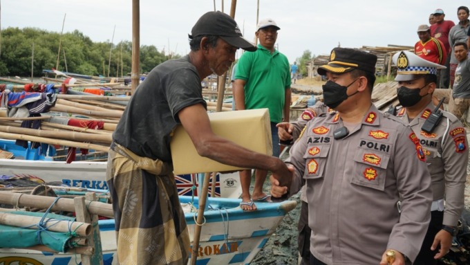 NELAYAN: Kapolres Gresik AKBP Mochamad Nur Azis saat memberikan paket sembako kepada nelayan di Kelurahan keroman, Kecamatan Gresik Kota.  (Ist./Radar Gresik)