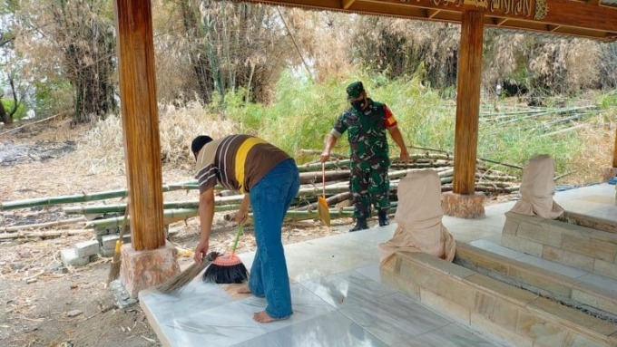 BERSIHKAN MAKAM: Warga Desa Leran dibantu anggota Koramil Manyar saat melakukan kerja bakti membersihkan ranting pohon yang tumbang akibat angin puting beliung di area Makam Panjang di Desa Leran, Kecamatan Manyar.  (Ist./Radar Gresik)