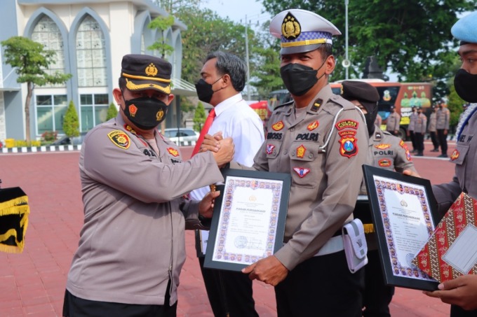 PENGHARGAAN: Kapolres Gresik AKBP Mochamad Nur Azis saat memberikan penghargaan ke anggotanya yang berperstasi di halaman Mapolres Gresik. (Ist./Radar Gresik)