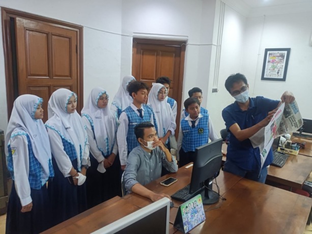 Sembilan jurnalis cilik SMP YIMI Gresik mendapatkan pengalaman menarik dari manajer pemasaran Radar Surabaya Indra Wijayanto. (Riri/Radar Gresik)
