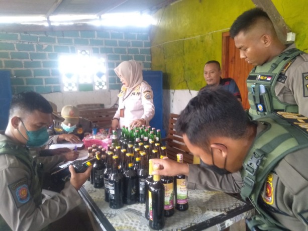 DIAMANKAN: Puluhan botol miras diamankan anggota Satpol PP dari warung di Ngimboh, Kecamatan Ujungpangkah. (Ist/Radar Gresik)
