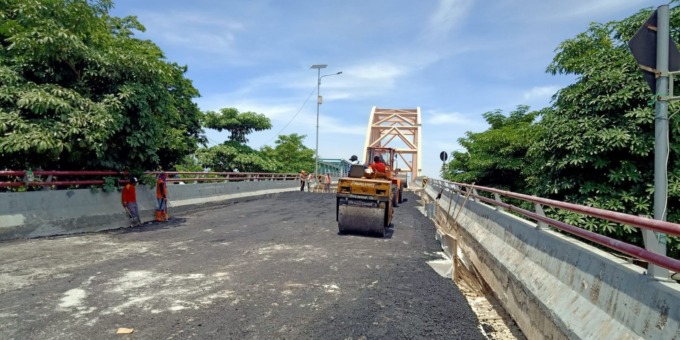 HAMPIR TUNTAS: Para pekerja saat melakukan pengaspalan Jembatan Sembayat II sisi selatan. (Rofiq/Radar Gresik)