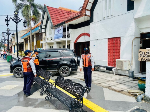 BERJAGA: Petugas Dishub Gresik saat meminta pemilik mobil memindahkan kendaraannya. (Dok/Radar Gresik)
