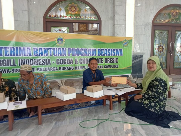 PEDULI: Perwakilan dari Cargill Adi Suprayitno memberikan bantuan untuk pelajar yang diwakili oleh guru Yatamam. (dok/radar gresik)