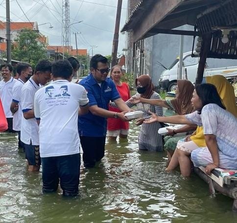 PRIHATIN: Selain memberikan bingkisan, kader Muda Partai Demokrat Farid Romawan juga berdialog dengan masyarakat korban bencana Kali Lamong. (Firmansyah/Radar Gresik)