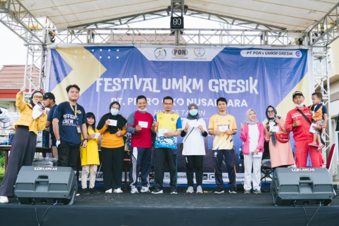 BERUNTUNG: Pengunjung Festival UMKM dalam rangka HUT PON ke 25 terliat ceria karena pulang membawa hadiah dari panita. (Dok/Radar Gresik)