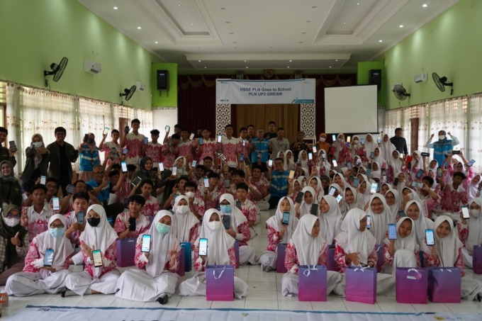 ANTUSIAS : Ratusan siswa SMAN 1 Gresik foto bersama sembari menunjukkan aplikasi PLN Mobile. (radar gresik/istimewa)