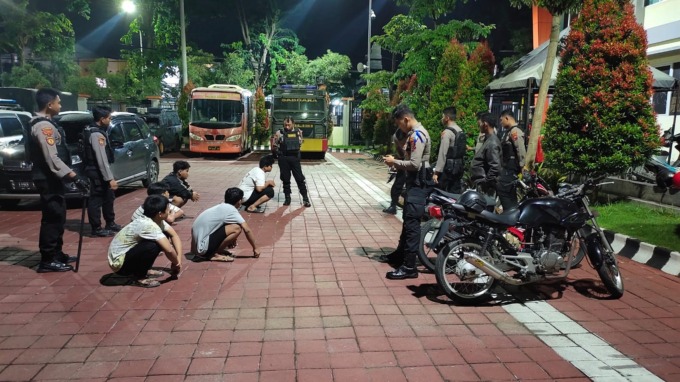 DIAMANKAN: Anggota Samapta Polres Gresik mengamankan beberapa pemuda yang minum-minuman keras dan balap liar di depan stadion Gelora Joko Samudro Jalan Veteran, Kecamatan Kebomas, kemarin. (ISTIMEWA/RADAR GRESIK)