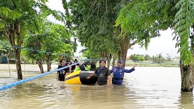 BANTU WARGA: Anggota Ditpolairud Polda Jatim Bersama Polres Gresik saat meninjau banjir dan memberikan bantuan sembako kepada warga menggunakan perahu karet di Desa Pandu, Kecamatan Cerme, Kamis (23/2). (Ist/Radar Gresik)