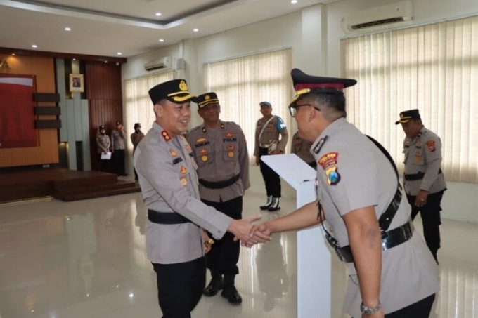 BERI SELAMAT: Kapolres Gresik, AKBP Adhitya Panji Anom saat menyalami mantan Wakapolres Gresik Kompol Kadek Oka Suparta usai sertijab di Mapolres Gresik.  (ISTIMEWA/RADAR GRESIK)
