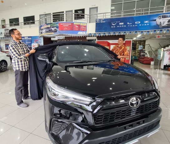 Sporty : Supervisor Marketing Arina Toyota Gresik, Handika dan Andre membuka tirai penutup mobil Toyota Corolla Cross Hybird GR Sport. (Firmansyah/Radar Gresik)