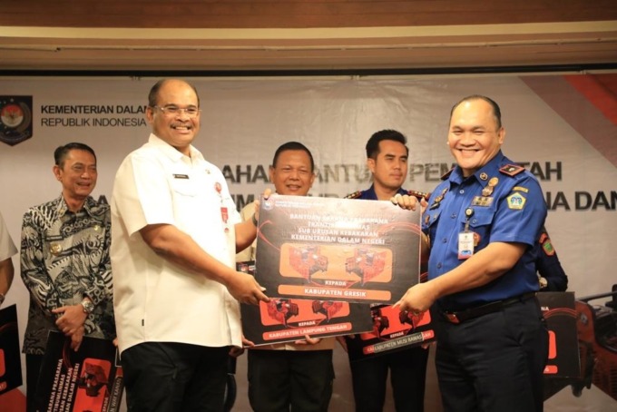 KINERJA BAIK: Dirjen Bina Administrasi Kewilayahan Kemendagri Syafrizal ZA secara simbolis menyerahkan bantuan pompa pemadam kepada Kepala Damkarla Gresik Agustin Halomoan Sinaga. (Ist/Radar Gresik)