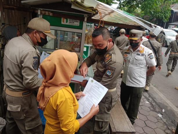HIMBAUAN : Kasatpol PP Suprapto dan anggota gabungan saat memberikan imbauan serta penertiban PKL yang berada di trotoar di wilayah Kecamatan Gresik. (Yudhi/Radar Gresik)