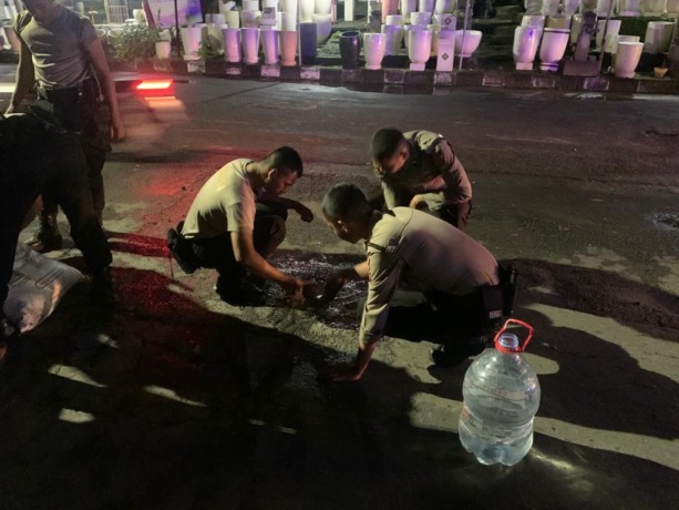 DITAMBAL : Anggota Satsampta Polres Gresik menambal jalan berlubang di Jalan Sumatra Perum GKB, Kecamatan Kebomas. (Ist/Radar Gresik)
