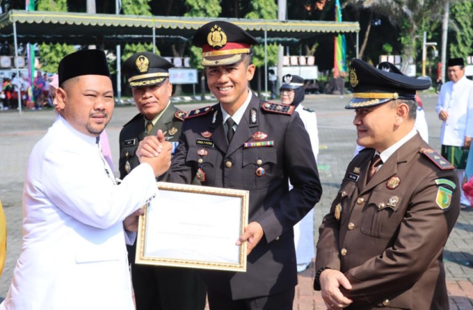 PENGHARGAAN : Wakapolres Gresik Kompol Erika Purwana Putra mewakili Polres Gresik saat menerima penghargaan Kamtibmas yang diberiian secara langsung oleh Bupati Gresik Fandi Akhmad Yani saat puncak peringatan HUT Pemkab Gresik ke-49 dan Hari Jadi Gresik k