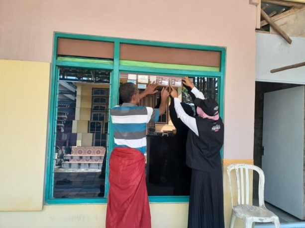VALIDASI: Petugas pantarlih saat menempelkan stiker di rumah-rumah warga. (Dok/Radar Gresik)