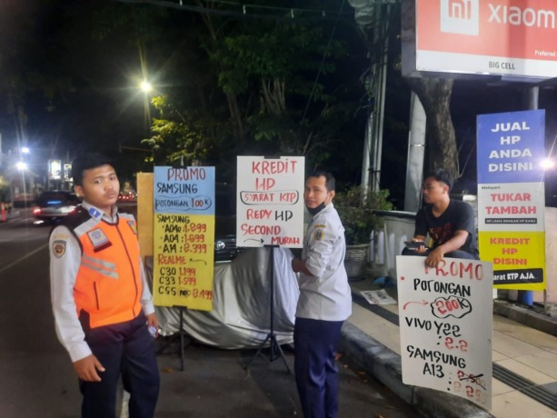 DITINDAK: Dinas Perhubungan Gresik menindak toko ponsel yang memasang papan promosi di jalan. (Firmansyah/Radar Gresik)