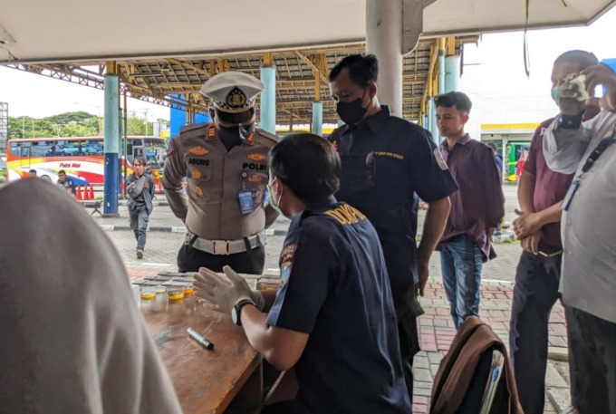 TES URINE: Petugas gabungan dari Satlantas Polres Gresik, Satreskoba Polres Gresik dan BNNK Gresik melakukan pengecekan tes urine kepada supir bus dan kondektur di Terminal Bunder, Kecamatan Cerme, kemarin.  (istimewa/radar gresik)