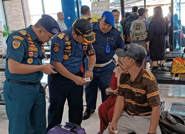 ANTISIPASI TIKET PALSU: Kepala KSOP Gresik, Hotman Siagian (tengah) memeriksa tiket yang dibawa penumpang untuk mengangisipasi adanya tindak pidana pemalsuan tiket. (Ist/Radar Gresik)