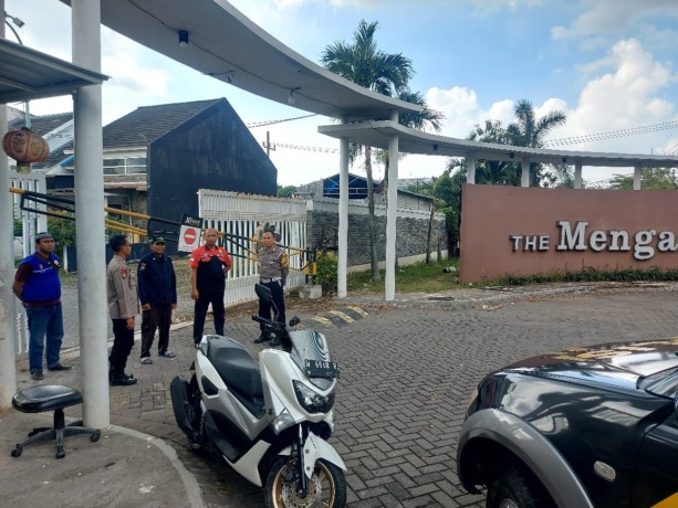 PATROLI LANGSUNG: Anggota Polsek Menganti melakukan patroli dan berkordinasi dengan salah satu Satpam perumahan agar jangan lengah mengawasi rumah ditinggal mudik. (Ist/Radar Gresik)