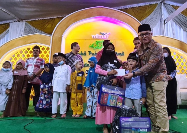 PEDULI : Direktur PT Wilmar Nabati Indonesia, Ridwan Brandes menyerahkan bantuan paket sembako dan santunan anak yatim untuk warga lima desa di sekitar perusahaan. (Dok/Radar Gresik)