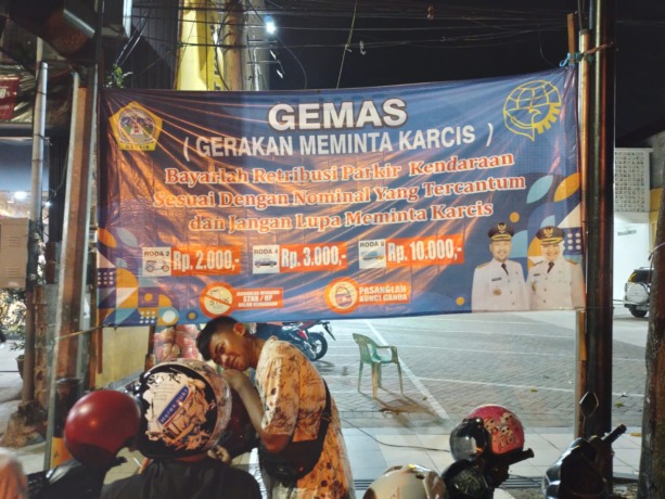 KEMBALI TUNAI: Dishub memasang sejumlah spanduk gerakan meminta karcis dititik titik parkir. (Ist/Radar Gresik)