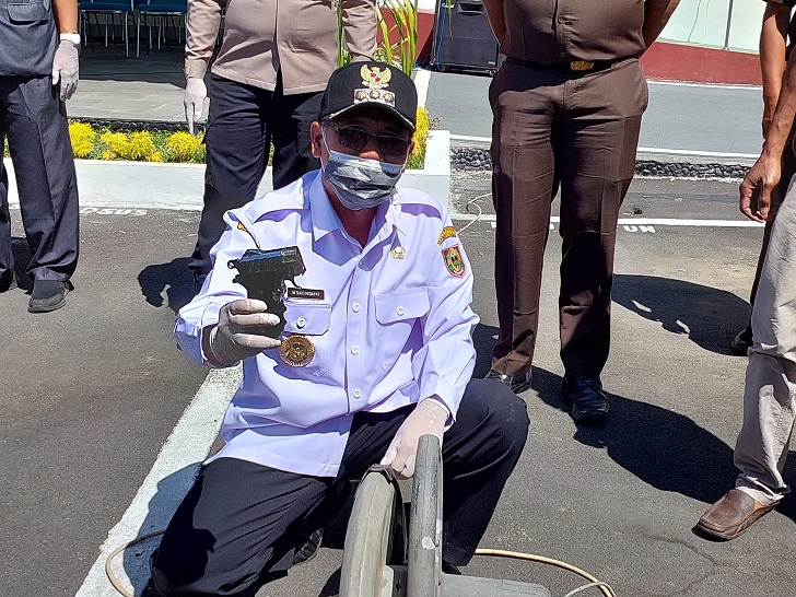 Bupati Boyolali M. Said Hidayat tunjukkan senajata api rakitan yang akan dimusnahkan di halaman Kejari Boyolali, Rabu (12/7/2023). (RAGIL LISTIYO/RADAR SOLO)
