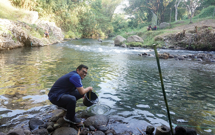 PEDULI: Direktur Sustainable Development Danone Indonesia, Karyanto Wibowo saat melakukan pelepasan ikan uceng dan tombro di Sungai Pusur.