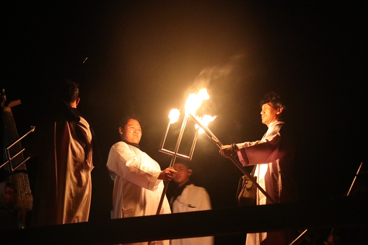 Warga menyalakan obor untuk penerangan turun dari bukit di Pantai Sembukan usai berdoa Selasa (18/7/2023). (IWAN ADI LUHUNG/RADAR SOLO)