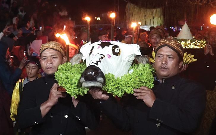 ADAT: Warga Desa Lencoh, Kecamatan Selo mengusung kepala kerbau untuk dilarung di kawah Gunung Merapi, Rabu (19/7/2023) malam.