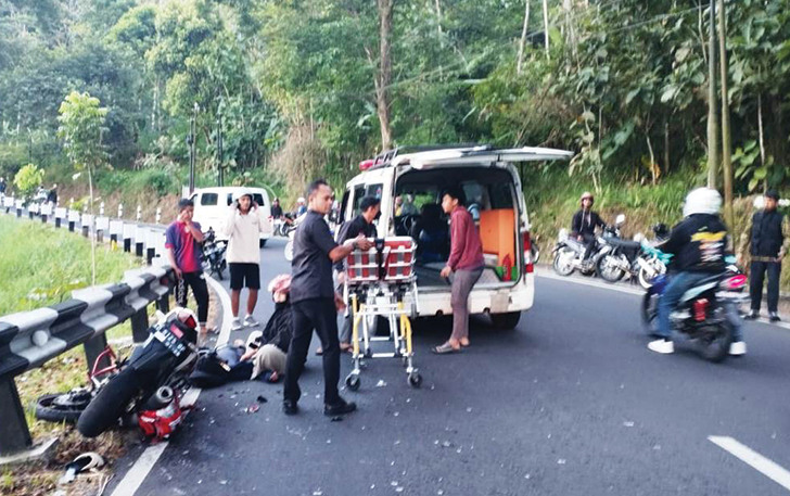 BERSERAKAN: Warga mengevakuasi pengendara yang terlibat kecelakaan lalu lintas di Desa Plumbon, Kecamatan Tawangmangu, kemarin (30/7/2023) pagi.