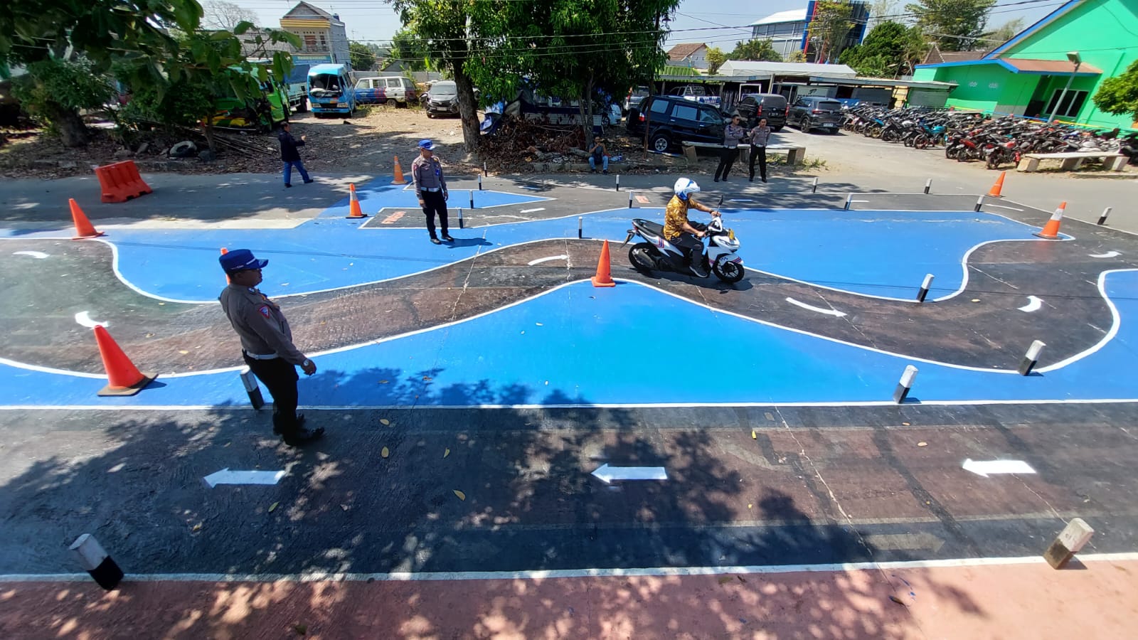 Petugas Satlantas Polres Boyolali saat memberikan contoh dalam uji praktik SIM C dengan lintasan baru berbentuk huruf S, Senin (7/8).