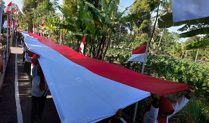 Puluhan warga Dusun Manggung, Desa Pager Jurang, Kecamatan Musuk, Kabupaten Boyolali mengirab bendera Merah Putih sepanjang 148 meter, Senin (14/8/2023). (RAGIL LISTIYO/RADAR SOLO)