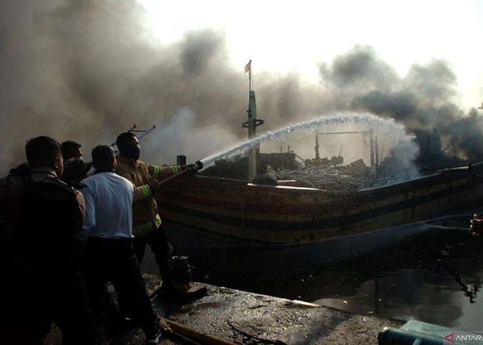 Petugas damkar berusaha memadamkan api yang membakar kapal-kapal milik nelayan di Pelabuhan Jongor, Tegal, Selasa (15/8).