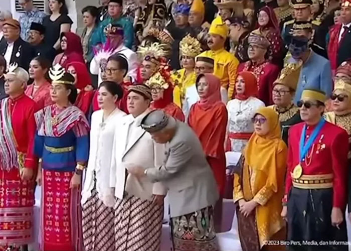 Momen Menteri Basuki Hadimuljono sedang menyibak jas Erick Thohir.