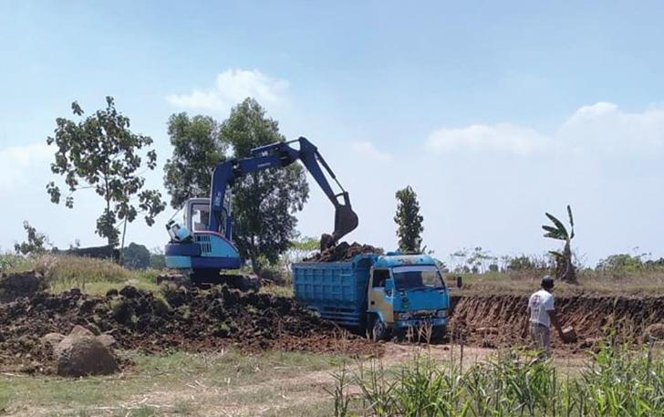 MARAK: Alat berat mengisi tanah uruk ke truk dump di salah satu lokasi penambangan galian C di Kabupaten Karanganyar, belum lama ini. Aktivitas penambangan diduga terjjadi di tanah kas desa.