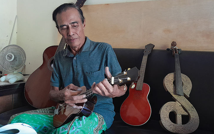 TETAP EKSIS: Sutarjo mencoba kualitas alat musik buatannya di rumahnya di Joyontakan, Serengan, Rabu (16/8)