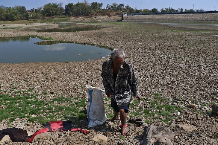 Warga mencari ikan di Waduk Tandon, Desa Pare, Kecamatan Selogiri, Kabupaten Wonogiri yang debit airnya menyusut drastis. (ARIEF BUDIMAN/RADAR SOLO)