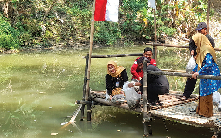 SIMBOLIS: Kepala Dispertan PP Karanganyar sebar benih ikan di Sungai Bolong, Karanganyar Kota, kemarin pagi (24/8).