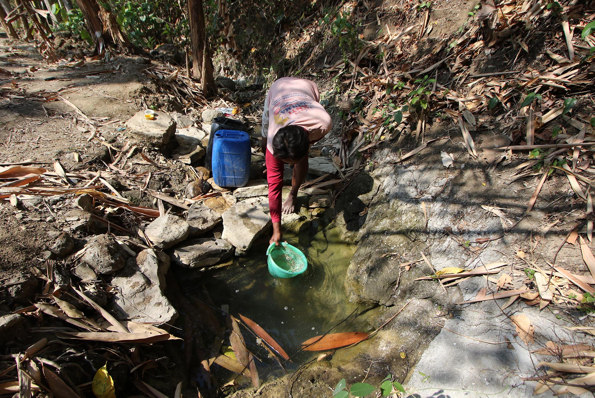 Warga Kalitlawah, Kecamatan Juwangi, Boyolali, mengais air dari genangan yang tersisa di sungai karena bantuan air bersih tak mencukupi.