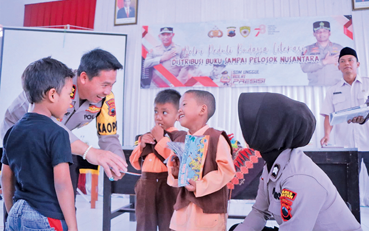DARI PERSONEL: Kapolres Klaten AKBP Warsono saat mendistribusikan buku di Balai Desa Joton, Kecamatan Jogonalan, kemarin.